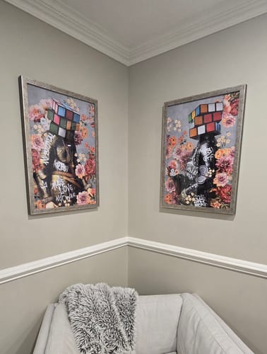 Customer's framed ill Cervello x La Mente art prints hung on living room walls above a fuzzy white chair.