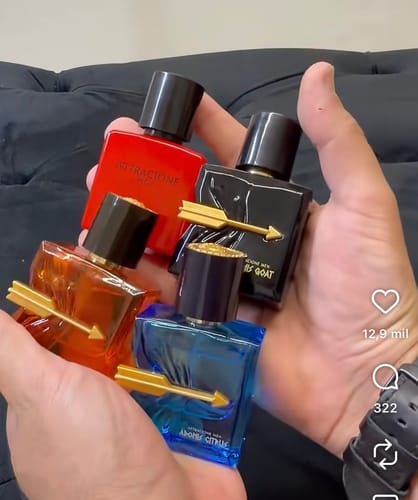 Customer's hands holding four colorful Kit Adonis perfume bottles with gold arrow detailing.
