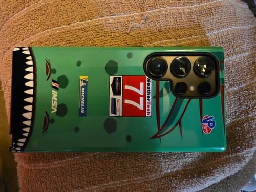 Kunden-Handyhülle mit Rexy Porsche 911 RSR-Design in Grün mit Renn-Logos und Haifischgebiss-Grafik.