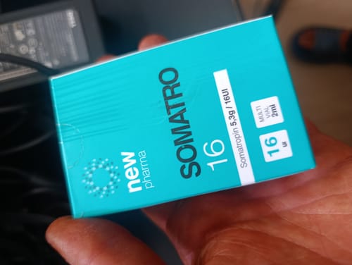 Customer's hand holding a turquoise New Pharma Somatro 16 product box.