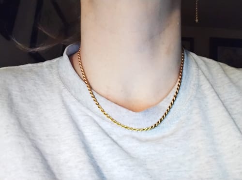 Customer's gold-toned Coco Rope Necklace worn snugly around a person's neck.