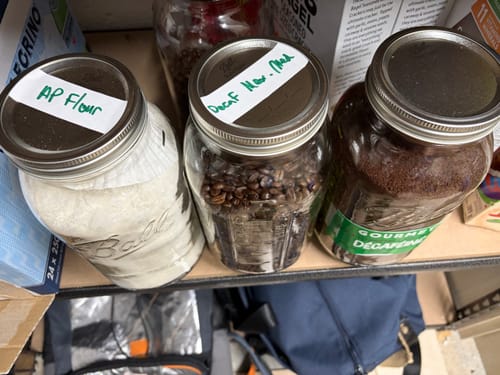 Customer's Mason Genie Vacuum Sealer Kit used on three glass mason jars filled with coffee and flour in a pantry.