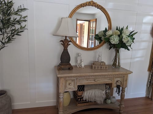 Customer's Brittany French Provincial Round Mirror with aged gold frame, styled above a wooden console table.