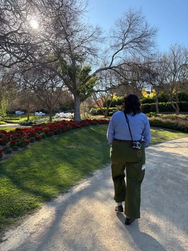 Customer's Construction Pants in hunter green being worn while walking in a sunny park.