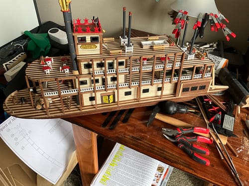 Customer's wooden Maqueta Barco Mississippi model in progress on a desk with tools and assembly instructions.