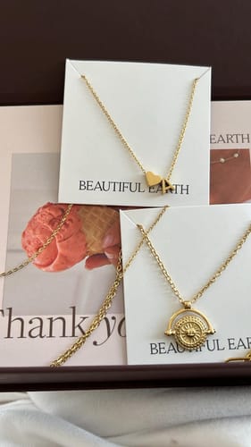 Customer's Golden Sun Coin Necklace featuring a round gold pendant, shown alongside another heart-shaped necklace.