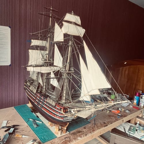 Customer's detailed ship model featuring Motón 4mm parts applied to the rigging and sails on a wooden workbench.