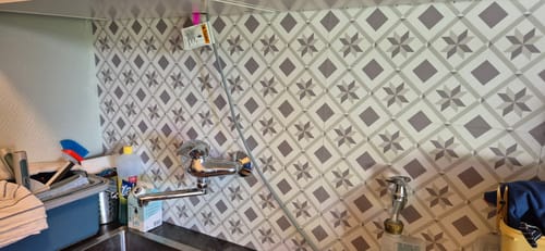 Customer's Oslo mini selvklebende fliser installert med stjernemønster på vaskeromsvegg bak vannkran.