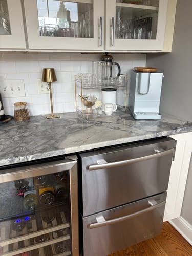 Reviewer's FLUR Latte Lovers Set glasses displayed on a modern kitchen counter next to a coffee machine.