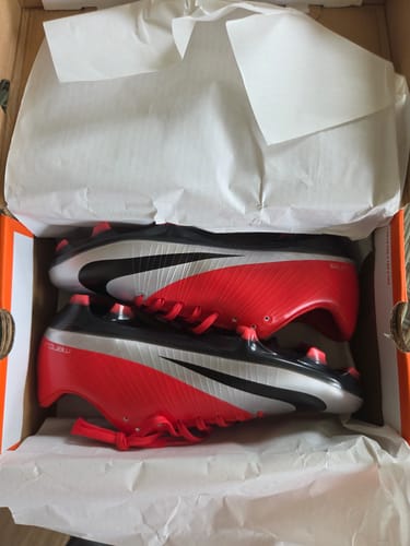 Customer's Nike Mercurial Vapor 5 football boots in red, black, and silver, neatly arranged inside the branded box.