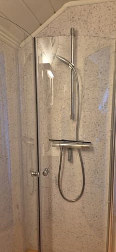 Customer's Lisboa Terrazzo hvit selvklebende fliser installert som moderne vegg i en dusjnisje.