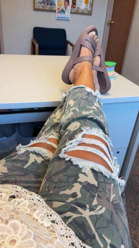 Customer's distressed camo Kreek jeans worn by a person, showing the cropped fit and leg rips.