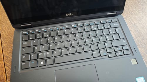 Customer's Dell Latitude 7390 2-in-1 laptop, showing the French AZERTY keyboard and trackpad in a well-lit space.