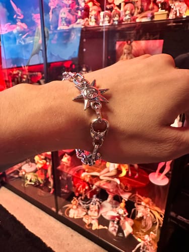 Customer's silver Astrology Bracelet worn on a hand, featuring a star-shaped charm with intricate detailing.