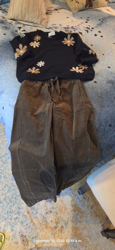 Customer's Be Cool Corduroy Drawstring Pants in olive, styled with a floral sweater on a bedspread.