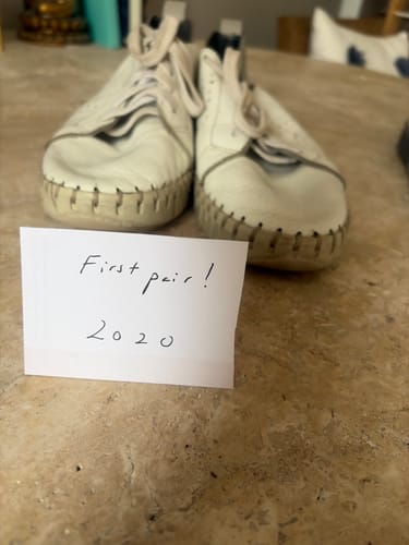 Customer's pair of white and grey Vida sneakers, with a handwritten note saying First pair 2020.
