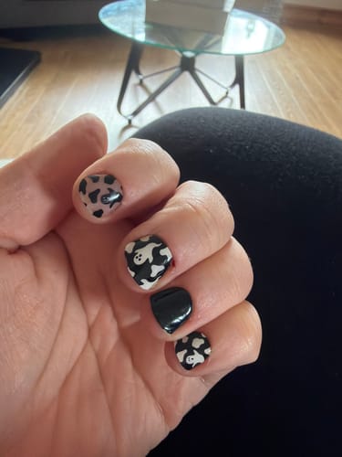 Customer's Mix & Match Refill Bundle featuring black and white ghost and cow print nail stickers on hand.