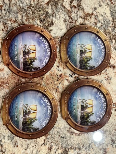 Customer's four personalized cruise cabin door magnets, circular with a tropical porthole scene and champagne toast.
