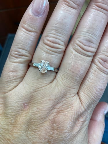 Reviewer's hand wearing a DovEggs oval lab grown diamond ring with two side baguette stones
