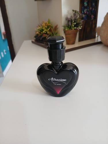 Customer's Attracione Sensual perfume bottle, heart-shaped with black glass, standing on a white surface.