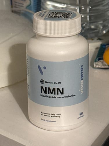 Flacon blanc de gélules Pure NMN 500 mg du client, avec étiquette bleu clair, posé sur une surface blanche.