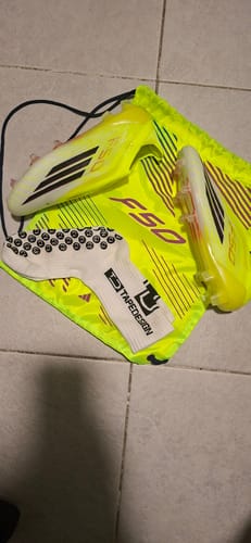 Customer's Adidas F50 Laceless Elite FG football boots in bright yellow with a matching drawstring bag and grip socks.