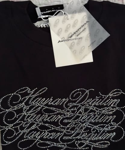Customer's siyah Radikal Merch Hayran Değilim tshirt ve üzerindeki taş detaylı yazıların yakın çekimi.