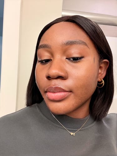 Reviewer wearing a dainty heart necklace and gold hoop earrings from the 5-piece bundle set.