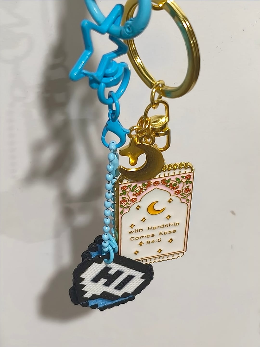 Customer photo review of HilalHaven "With Hardship Comes Ease" Gentle Assurance  Floral‑Bordered Charm with Moon‑Star Accent Enamel Keychain
