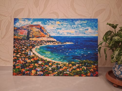 Customer's Golfo di Mondello painting displayed on a table with a plant, showing vibrant sea colors.