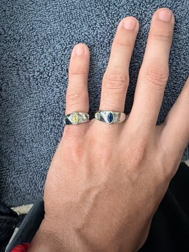 Reviewer's hand wearing two HJ Birthstone Rings featuring marquise-cut yellow and blue stones on fingers.