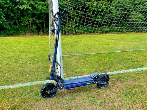 Customer's Ausom Gosoul 2 electric scooter parked on a grassy field in front of a soccer goal net.