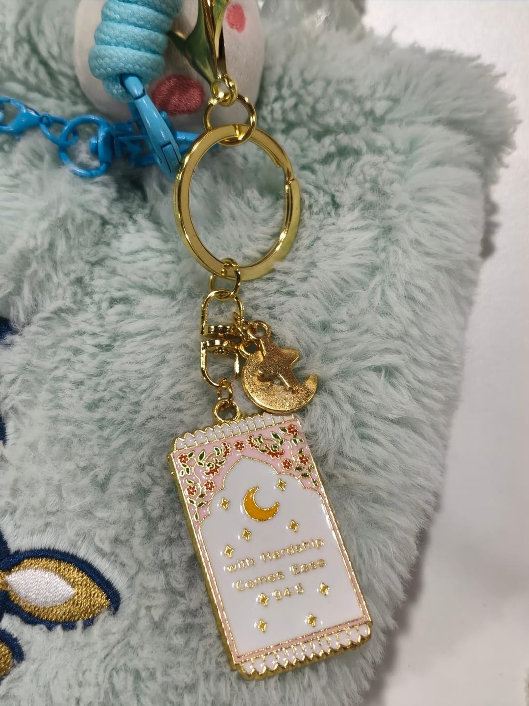 Customer photo review of HilalHaven "With Hardship Comes Ease" Gentle Assurance  Floral‑Bordered Charm with Moon‑Star Accent Enamel Keychain