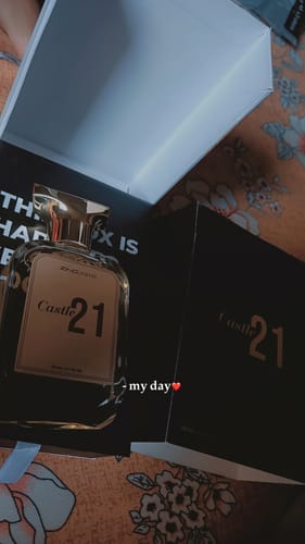 Customer's Castle 21 perfume bottle and elegant black box, shown opened on a floral background.