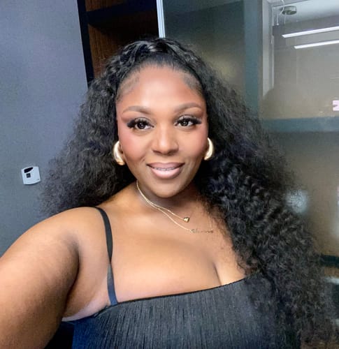 Reviewer's Butter Fringe Stirrup Jumpsuit in black, shown in a close-up mirror selfie.