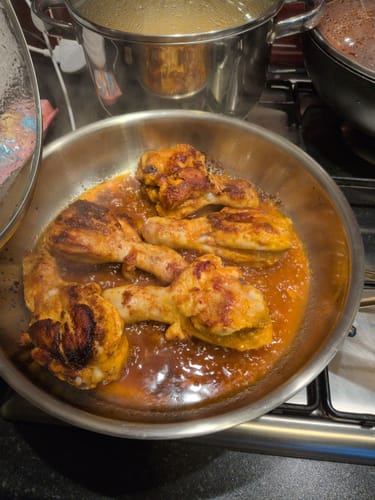 Customer cooking chicken drumsticks in an Okura pan