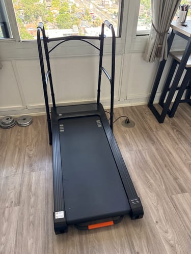 Customer's NovaWalk W50 TrekPad set up on a wooden floor near a window, with attached stability handles.