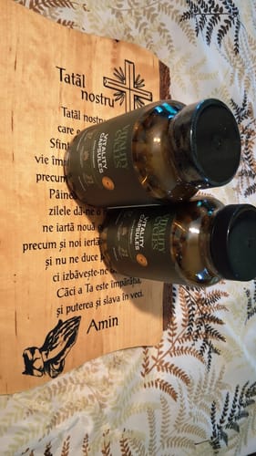 Customer's two dark Extra Strength Vitality Capsules bottles resting on a wooden prayer board