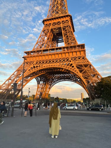 Reviewer standing in front of the Eiffel Tower wearing a Golden Moss Premium Modal hijab.