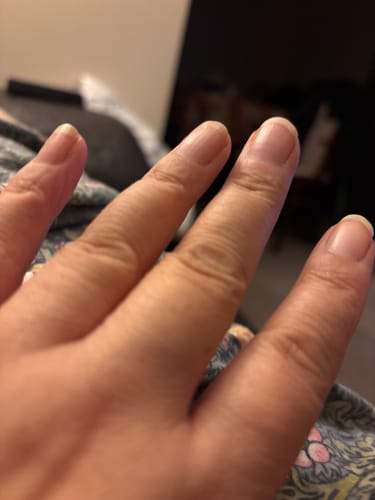 Customer's hand showing long, healthy natural nails after using Holy Saver Bundle.