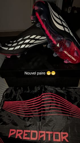 Customer's Adidas Predator 26 Elite Laceless FG shoes in black, white, and red resting on their black product box.