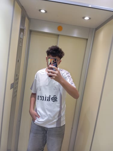Customer's T-Shirt Skicen worn in a mirror selfie, showing the white shirt with black graphic lettering and grey panels.