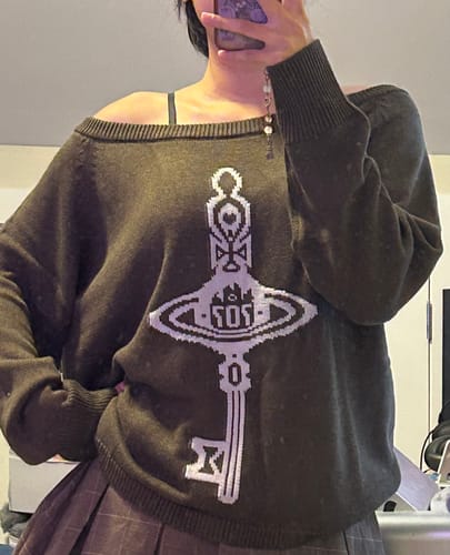 Customer's dark brown Key Knit Sweater with a prominent jacquard key design, worn with a soft off-the-shoulder fit.