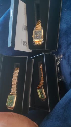 Customer's three Claire De Mains watches in open black gift boxes, each with a gold metal band.