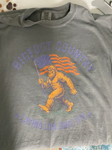 Customer's gray Bigfoot Country T-shirt with the printed graphic appearing faded and hard to read.