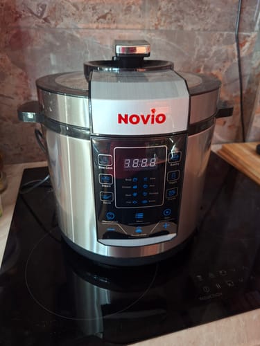 Customer's Novio SteelCook multicooker with a silver stainless steel finish placed on a black induction cooktop.