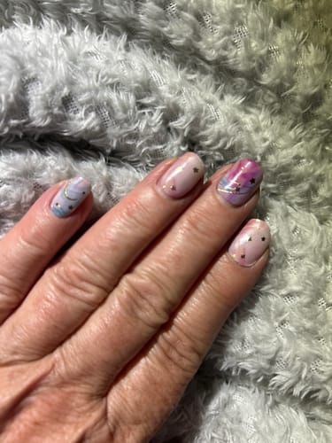 Reviewer's Stardust Marble UV Gel nail wraps featuring a pink and purple marble design with gold star details.