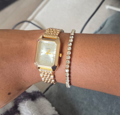Customer's gold Claire De Mains watch with a rectangular face and metal link band worn on their wrist.