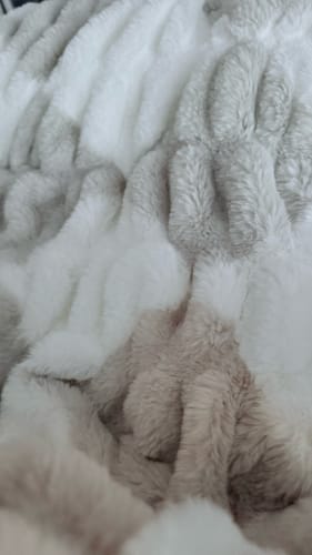 Customer's close-up of the Hugs Diamond Ancient Scroll Blanket showing the plush, cream and tan patterned fabric.