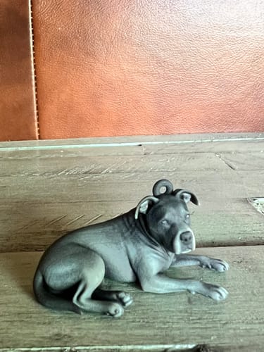Customer's Custom Pet Chibi Figure Keychain of a dog, resting on a wooden surface.